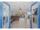 Open living room with hardwood floors, leather sectional sofa, and access to a balcony at 7092 Baypine Ln, Englewood, FL 34224