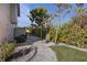 Landscaped side yard with stone pathway and lounge chair at 7092 Baypine Ln, Englewood, FL 34224