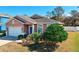 Landscaped yard with tan house, white garage door, and blue front door at 2729 Walden Woods Dr, Plant City, FL 33566