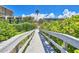 Wooden walkway through lush greenery leads to the beach at 7532 Bayshore Dr # 203, Treasure Island, FL 33706