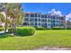 Three-story building with balconies and lush lawn at 7532 Bayshore Dr # 203, Treasure Island, FL 33706