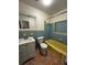 Retro bathroom with yellow tub, blue tile, and white vanity at 10206 N Oakleaf Ave, Tampa, FL 33612