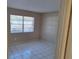 Bedroom features a window with blinds allowing natural light to illuminate the tile floor at 4885 Rilma Ave # 130, Sarasota, FL 34234
