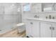 Modern bathroom with glass shower, white vanity, and wood-look tile floor at 7326 Shepherd St, Sarasota, FL 34243