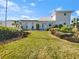 White single-story home with a modern design, landscaped lawn, and lush greenery at 7326 Shepherd St, Sarasota, FL 34243