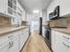 Modern kitchen with white cabinets, stainless steel appliances, and a breakfast bar at 7326 Shepherd St, Sarasota, FL 34243
