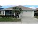 Single-story home with attached garage, palm trees, and well-manicured lawn at 1835 Scarlett Ave, North Port, FL 34289