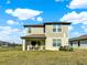 Backyard view features a covered patio with rocking chairs and lush lawn space at 9189 Royal River Cir, Parrish, FL 34219