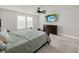 Bright bedroom features soft carpet, ceiling fan, and a modern media center at 9189 Royal River Cir, Parrish, FL 34219