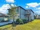 Two-story home with blue siding, lush landscaping, and a well-maintained front lawn under a partly cloudy sky at 9189 Royal River Cir, Parrish, FL 34219