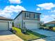 Two-story home with a driveway leading to the garage and a well-maintained lawn at 9189 Royal River Cir, Parrish, FL 34219