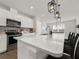 Bright kitchen featuring an island with quartz countertops, stainless steel appliances, and modern pendant lighting at 9189 Royal River Cir, Parrish, FL 34219