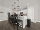 Kitchen island with seating, pendant lights, and views into an open floorplan. Includes white cabinets at 9189 Royal River Cir, Parrish, FL 34219