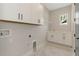 Bright laundry room with white cabinets and vinyl flooring at 111 S Cooper Pl, Tampa, FL 33609