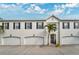 Three-unit building front elevation, featuring attached garages and landscaping at 2607 W Cleveland St # B, Tampa, FL 33609