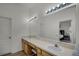 Double vanity bathroom with a large mirror and light fixtures at 30350 Grymes Dr, Wesley Chapel, FL 33545
