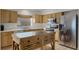 Kitchen with light wood cabinets, stainless steel appliances, and an island at 30350 Grymes Dr, Wesley Chapel, FL 33545