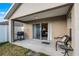 Covered patio with grilling area, seating, and sliding glass door leading to the interior at 30350 Grymes Dr, Wesley Chapel, FL 33545