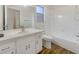 Updated bathroom with a white vanity, bathtub, and neutral tile at 5220 Lords Ave, Sarasota, FL 34231