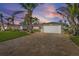 Single-story home with gray exterior, solar panels, and paver driveway at 8017 13Th S Ave, St Petersburg, FL 33707