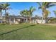 Single-story home with gray exterior, solar panels, and lush landscaping at 8017 13Th S Ave, St Petersburg, FL 33707