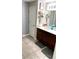 Bathroom featuring double sinks, dark wood cabinets, and neutral tile flooring at 39567 Dawson Chase Dr, Zephyrhills, FL 33540