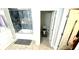 A bathroom featuring a shower with niche, toilet room and hall access, with neutral tile floors at 39567 Dawson Chase Dr, Zephyrhills, FL 33540