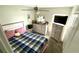 Bright bedroom featuring a ceiling fan, bed with plaid bedding, and modern dresser at 39567 Dawson Chase Dr, Zephyrhills, FL 33540