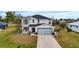 Two-story house with light gray siding, gray roof, and a light blue garage door at 25393 Durango Ct, Punta Gorda, FL 33955