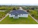 New construction home with a large grassy yard and a paved driveway at 13438 Mcintosh Ave, Port Charlotte, FL 33981