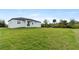 Green lawn surrounds this white modern home, creating a serene outdoor space at 13438 Mcintosh Ave, Port Charlotte, FL 33981