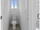 Bright bathroom featuring a toilet, white walls, and a window at 13438 Mcintosh Ave, Port Charlotte, FL 33981