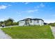 Modern home with a pristine lawn and a sign in the yard at 13438 Mcintosh Ave, Port Charlotte, FL 33981