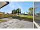 Attractive gray pavers form a back patio overlooking a well-maintained lawn with palm trees and a charming wooden fence at 105 12Th Sw St, Ruskin, FL 33570