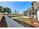 Landscaped backyard with a crushed rock pathway leading to the back of the home and screened porch at 105 12Th Sw St, Ruskin, FL 33570