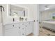 Bright bathroom featuring a double sink vanity and a view of the primary bedroom at 105 12Th Sw St, Ruskin, FL 33570