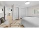 Bright bedroom featuring a light-colored rug, closet with bi-fold doors, and a comfortable bed with decorative pillows at 105 12Th Sw St, Ruskin, FL 33570