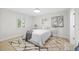 Bright bedroom featuring natural light, a comfortable bed, and a light-colored rug on wood flooring at 105 12Th Sw St, Ruskin, FL 33570