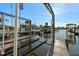 Dock area featuring boat lifts and a wooden dock with beautiful clear water and boat house at 105 12Th Sw St, Ruskin, FL 33570