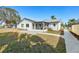 The backyard boasts a screened patio, stone path, and well-maintained lawn with lush greenery at 105 12Th Sw St, Ruskin, FL 33570