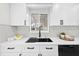 Bright kitchen sink area with modern fixtures, white cabinets, and natural light at 105 12Th Sw St, Ruskin, FL 33570
