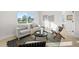 Naturally lit living room with sofa, chairs, stylish rug, and a bright window overlooking the front yard at 105 12Th Sw St, Ruskin, FL 33570
