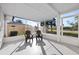 A screened-in porch features a pair of chairs and a view of the backyard's lawn and palm trees beyond the fence at 105 12Th Sw St, Ruskin, FL 33570