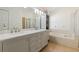 Elegant bathroom featuring double sinks, marble countertop, cabinet storage, shower and tub, all creating a luxurious space at 12417 Adventure Dr, Riverview, FL 33579