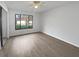 Well-lit bedroom with light wood-look flooring, ceiling fan, and a large window at 18315 Aintree Ct, Tampa, FL 33647