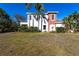 Charming two-story home with well-manicured lawn and mature palm trees enhancing its curb appeal at 3107 Pine St, Bradenton, FL 34208