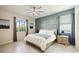 Bright bedroom features a ceiling fan, two windows, and a decorative blue accent wall at 11400 Burgundy Dr, Venice, FL 34293