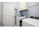 Well-lit laundry room features a washer, dryer, cabinet storage, and a door to the rest of the home at 11400 Burgundy Dr, Venice, FL 34293