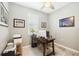 Home office with neutral walls, a wooden desk, a ceiling fan, and natural light at 11400 Burgundy Dr, Venice, FL 34293