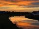 Scenic view of a pond reflecting the vibrant colors of the sunset sky at 11400 Burgundy Dr, Venice, FL 34293